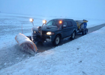 Jeep met sneeuwschuif en zoutstrooier